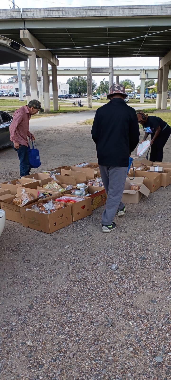 Neighbors receiving boxes of food at an outdoor distribution